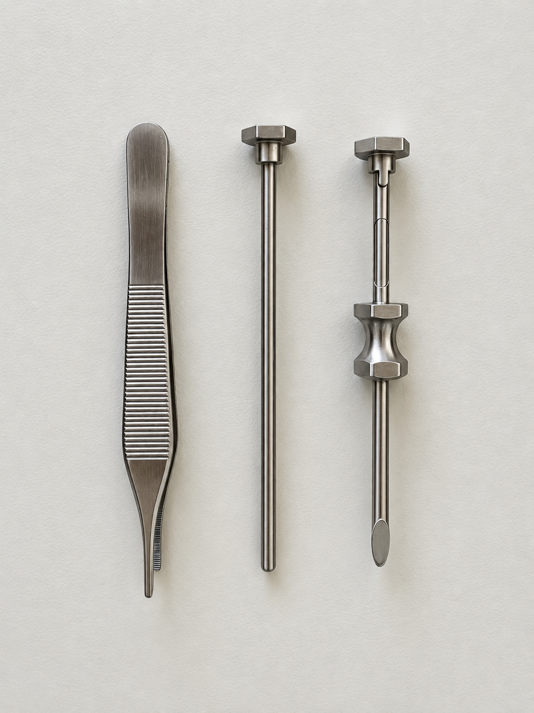 Three stainless steel dental instruments laid out vertically: a blade-like scaler on the left and two long slender probes with knurled knobs on top against a light gray background.